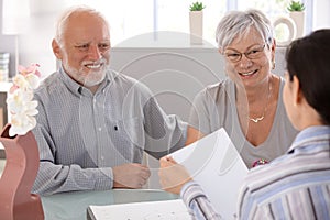 Senior couple at financial advisor smiling