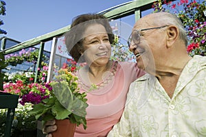 Senior Couple Among Flowers At Plant Nursery