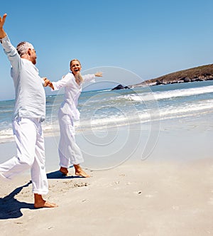 Senior couple fooling around on the beach