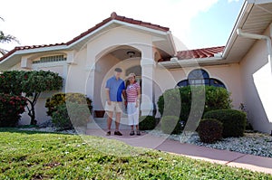 Senior couple in front of home