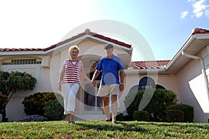 Senior couple in front of home