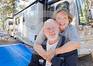 Senior Couple In Front of Their Beautiful RV At Campground. photo