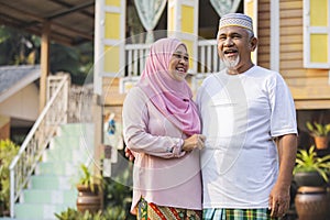 Senior couple in front of wooden house