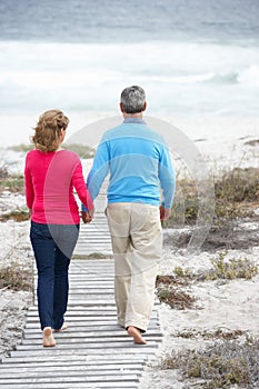 Senior couple going for romantic walk by sea