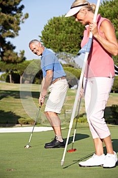 Senior Couple Golfing On Golf Course