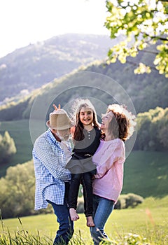 Senior couple with granddaughter outside in spring nature, relaxing and having fun.