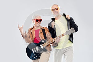 Senior couple with guitar showing rock hand sign