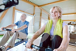 Senior couple in the gym on a rowing machine