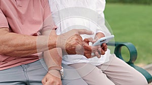 Senior couple, hands and cellphone on bench in park, typing and internet connection with bonding together. Mature people