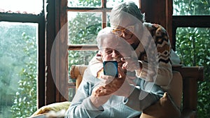Senior couple have fun together at home using mobile phone to do video conference call to friends or parents. Happy old man and