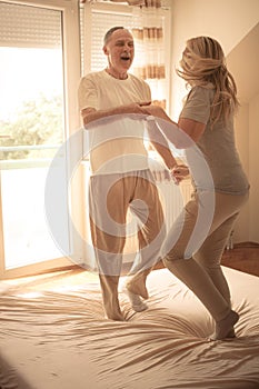 Senior couple having fun on bed.