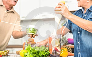 Senior couple having fun in kitchen with healthy veggie food