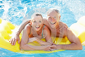 Senior couple having fun in pool photo