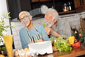 Senior couple having fun while preparing food