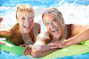 Senior Couple Having Fun In Swimming Pool