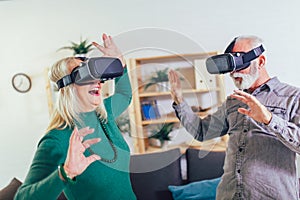 Senior couple having fun with virtual reality glasses