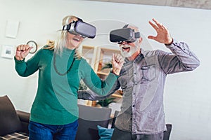 Senior couple having fun with virtual reality glasses