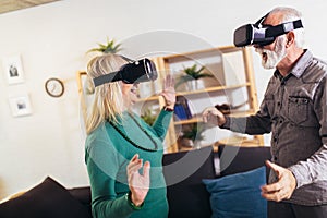 Senior couple having fun with virtual reality glasses.