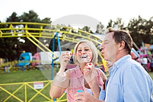 Senior couple having a good time at the fun fair