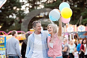 Senior couple having a good time at the fun fair