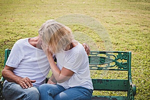 Senior couple having romantic time in a park, making out.