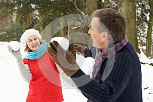 Senior Couple Having Snowball Fight