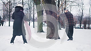 Senior couple having a snowball fight in park