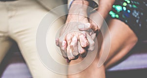 Senior couple having tender moments outdoor - Mature people holding each other hands sitting outdoor - Love, support and joyful