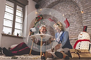 Senior couple having video call with grandchildren on Christmas day