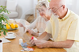 Senior couple with health problems reading leaflets of drugs photo