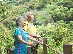 Senior couple hiking in nature park and looking up
