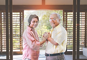 Senior couple holding hands for love and togetherness concept in asian wooden home background