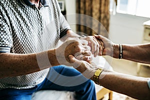 Senior couple holding hands together