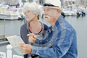 senior couple holding map and looking stressed