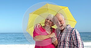 Senior couple holding umbrella