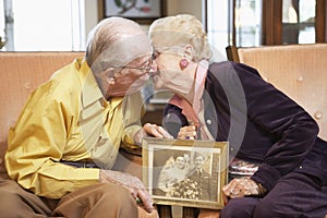 Senior couple holding wedding photo