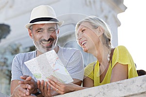 senior couple on holiday laughing togather while looking at map photo