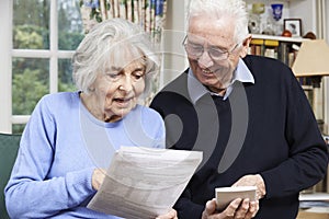 Senior Couple At Home With Bills Checking Home Finances