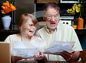 Senior couple at home with many bills