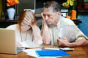 Senior couple at home with many bills photo