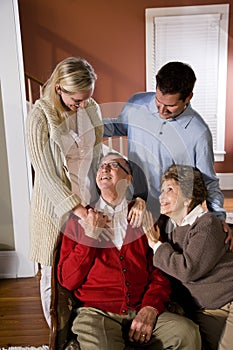 Senior couple at home on sofa with adult children