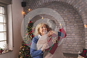 Senior couple hugging while exchanging Christmas presents