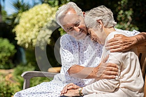 Senior couple hugging at hospital garden