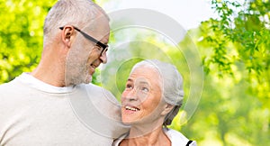 Senior couple hugging over natural background