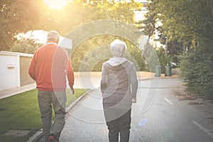 Senior couple jogging in city park together.