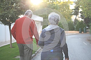 Senior couple jogging in city park together.