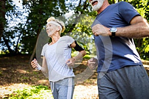 Senior couple jogging and running outdoors in nature