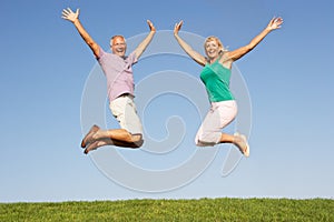 Senior couple jumping in air