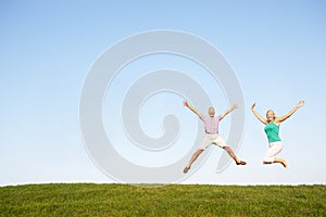 Senior couple jumping in air