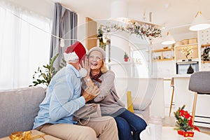 Senior couple kissing while exchanging Christmas presents